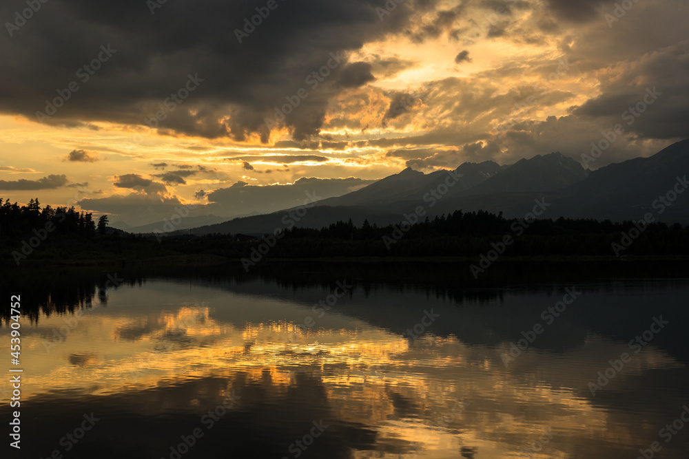 Sunset over the lake and High Tatras mountains, Slovakia. Popular fishing spot and public beach near Svit town.
