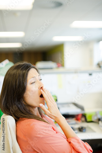 Businesswoman yawning at desk