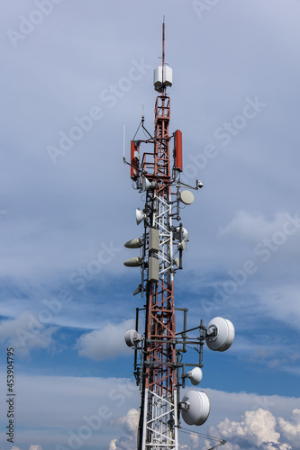 Steel broadcasting antenna tower with forest, sky and clouds in background. Eastern Slovakia near High Tatras.