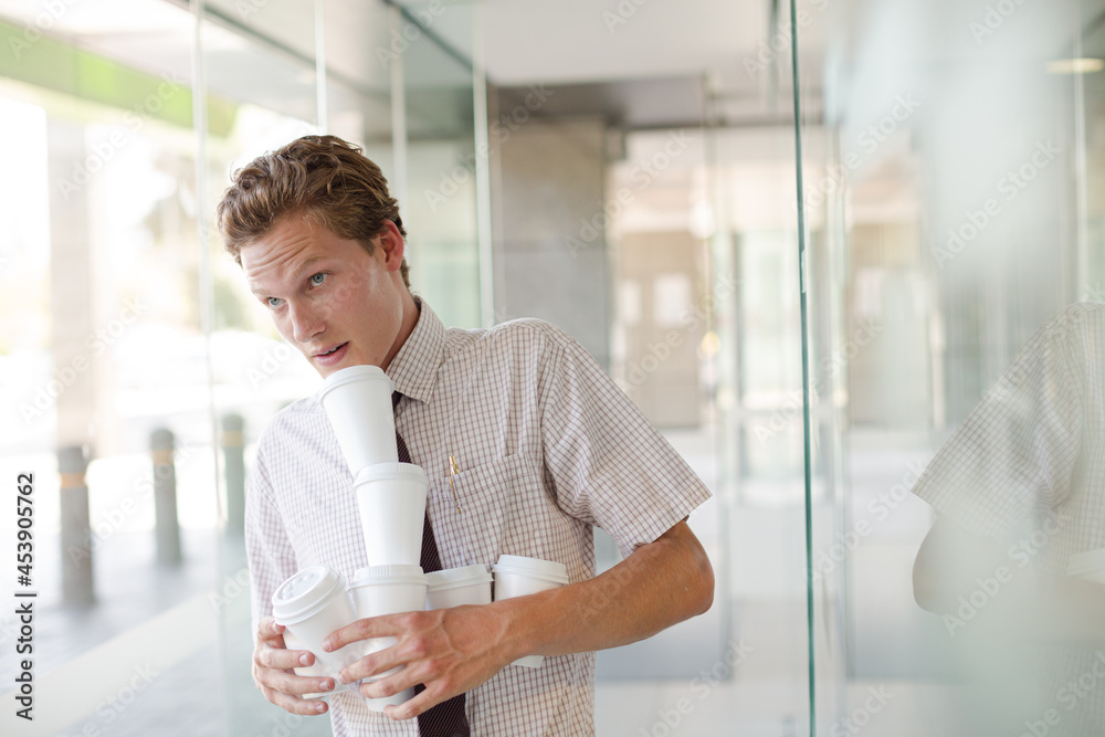 Businesswoman balancing coffee cups in office