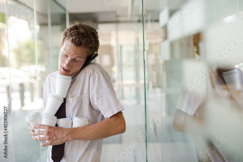 Businesswoman balancing coffee cups in office