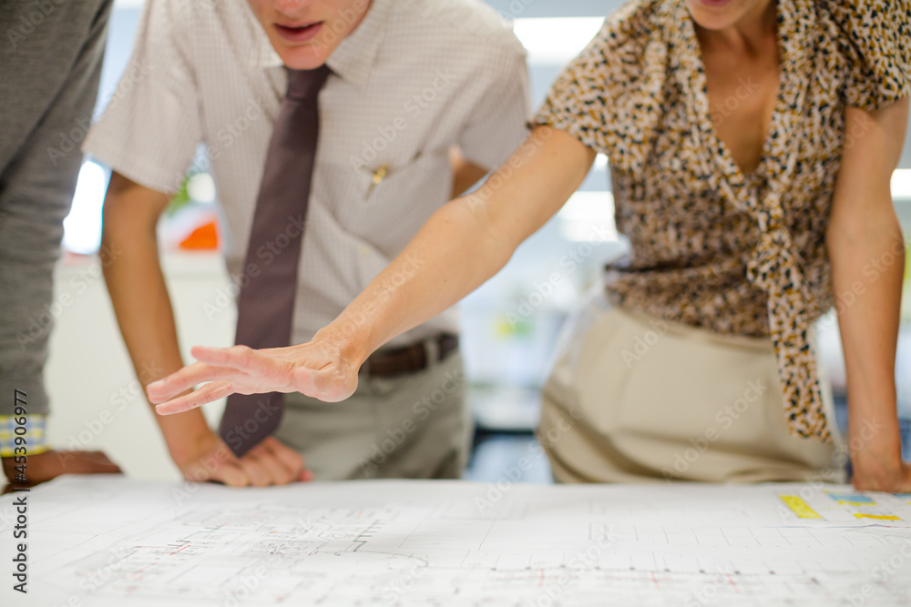 Business people reading blueprints in meeting Business people reading blueprints in meeting