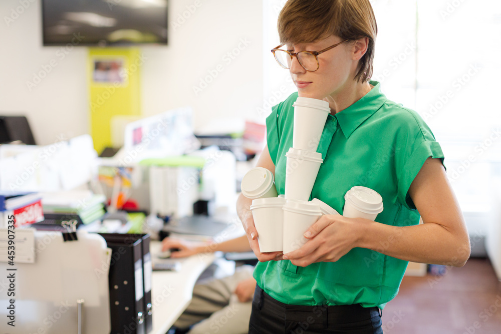 Businesswoman balancing empty coffee cups Businesswoman balancing empty coffee cups