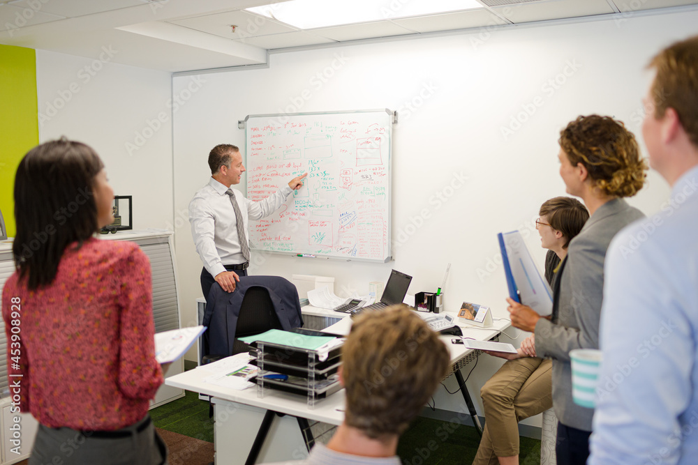 © KOTO - Businessman drawing on whiteboard in meeting