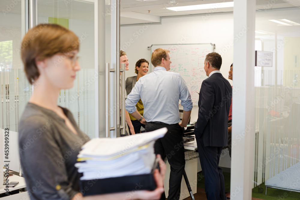 Obraz premium Businesswoman carrying pile of documents in office