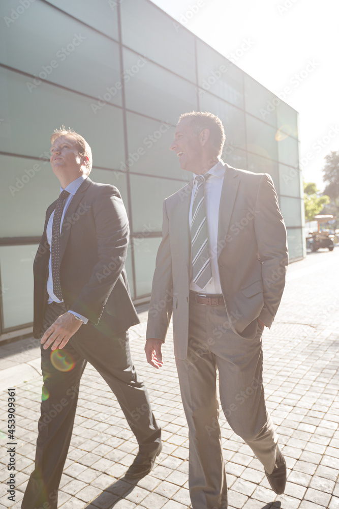 Businessmen walking on city street Businessmen walking on city street