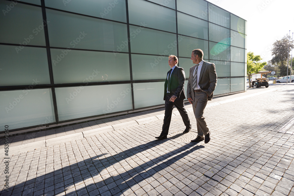 Businessmen walking on city street Businessmen walking on city street