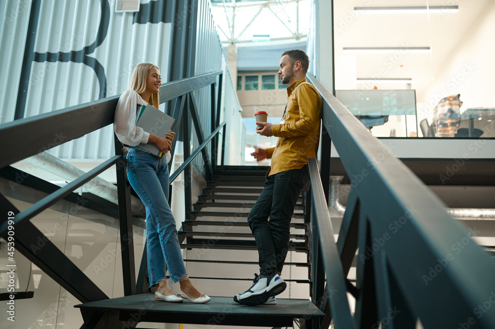 Two managers talks on stairs in IT office Two managers talks on stairs in IT office