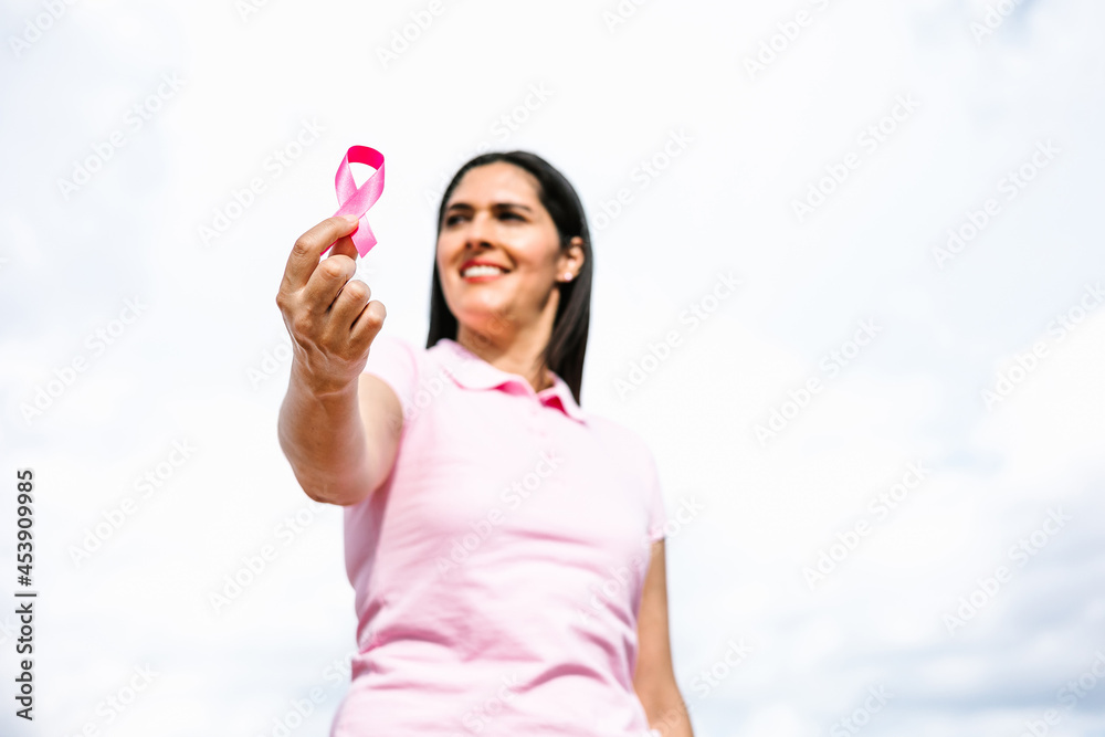 portrait of hispanic woman hand holding pink breast cancer awareness ribbons in Mexico Latin America portrait of hispanic woman hand holding pink breast cancer awareness ribbons in Mexico Latin America