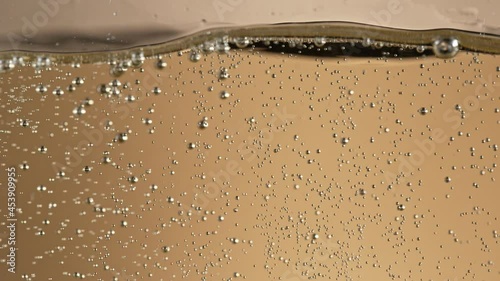 Super slow motion of champagne bubbles going up. Macro shot, filmed on high speed cinematic camera at 1000 frames per second. photo