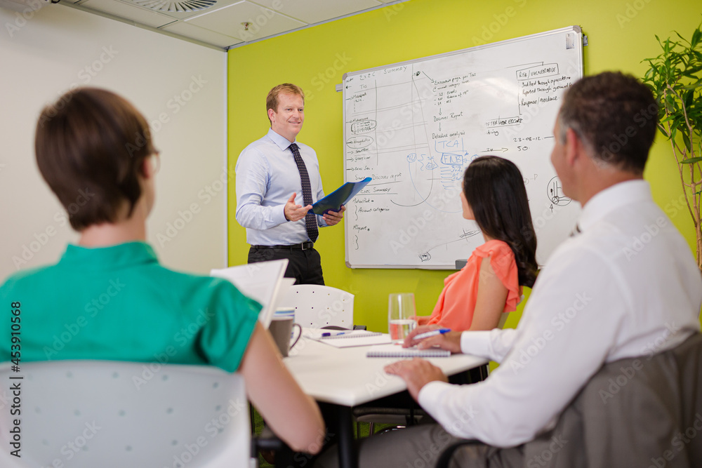 Businessman drawing on whiteboard in meeting Businessman drawing on whiteboard in meeting