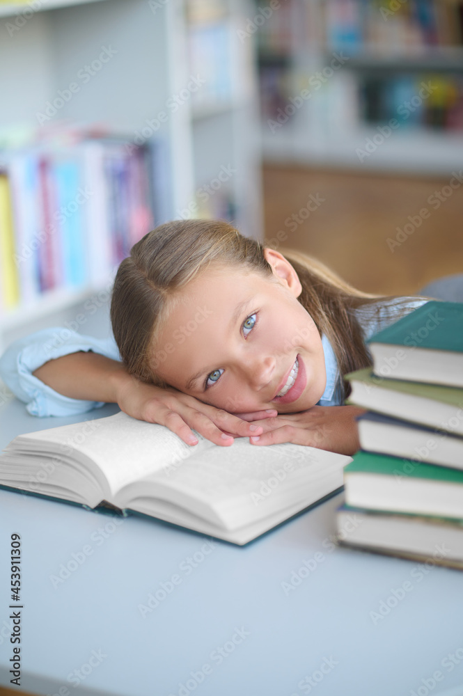 Joyous pretty schoolgirl lying on a library book Joyous pretty schoolgirl lying on a library book