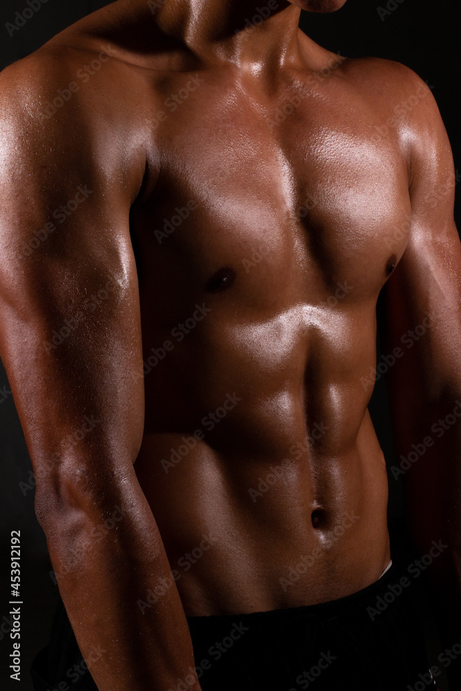 Well-built athletic latin man posing without a shirt. Strong and fit man bodybuilder. Sporty muscular guy athlete. Sport and fitness concept. Men's fashion Well-built athletic latin man posing without a shirt. Strong and fit man bodybuilder. Sporty muscular guy athlete. Sport and fitness concept. Men's fashion