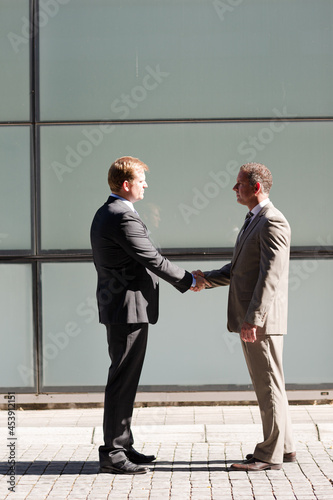 Businessmen shaking hands outdoors