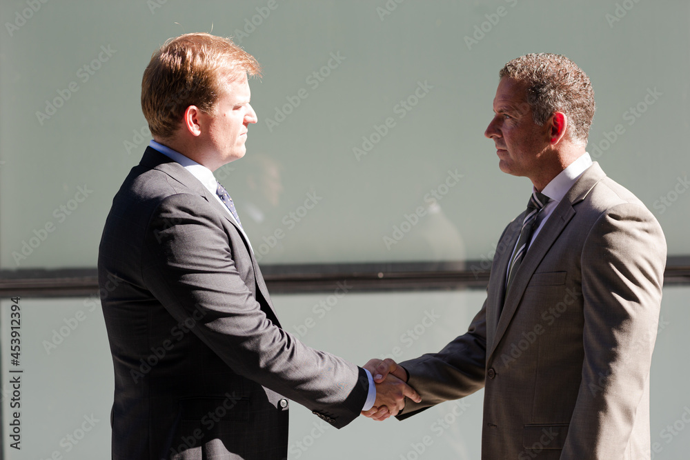 Businessmen shaking hands outdoors Businessmen shaking hands outdoors
