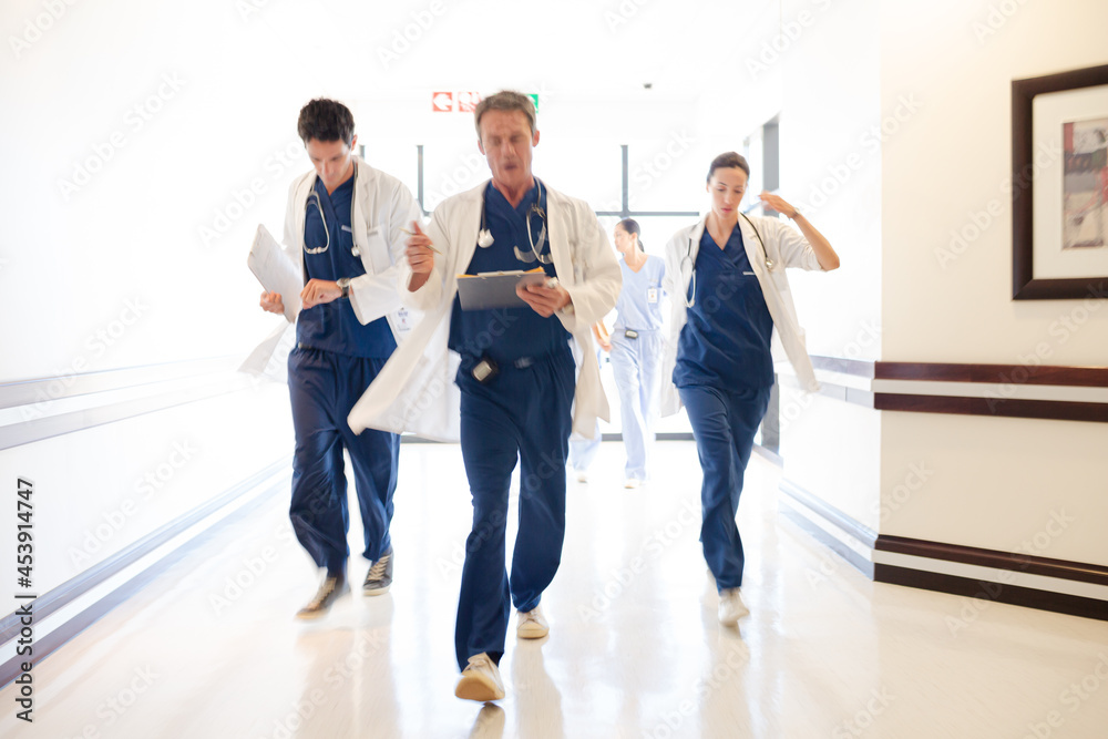 Fototapeta premium Doctors rushing down hospital corridor