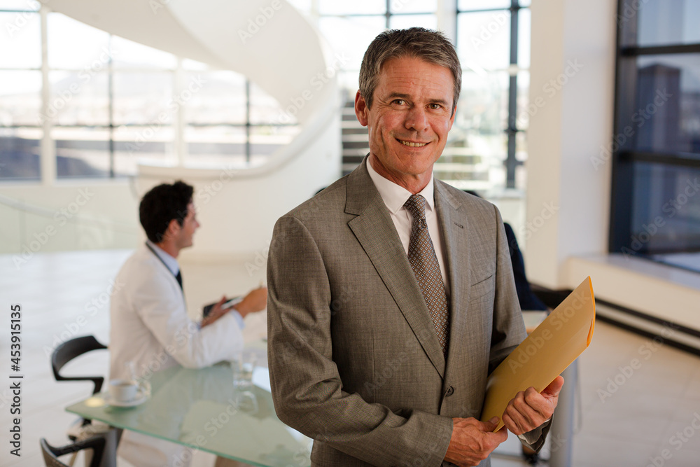 Portrait of smiling businessman in meeting with doctors Portrait of smiling businessman in meeting with doctors