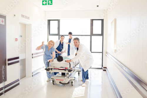 Doctors rushing patient on gurney in hospital corridor