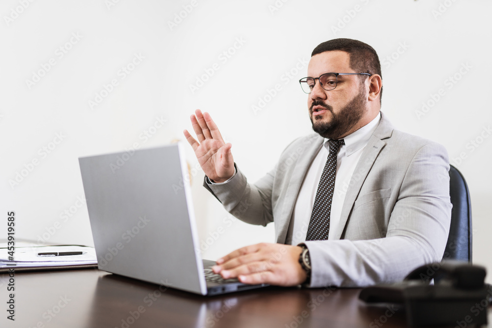 Businessman in a video conference with laptop and documents on his desk, consultant lawyer concept. Businessman in a video conference with laptop and documents on his desk, consultant lawyer concept.