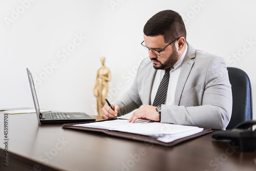 Businessman working in office with laptop and documents on his desk, consultant lawyer concept.