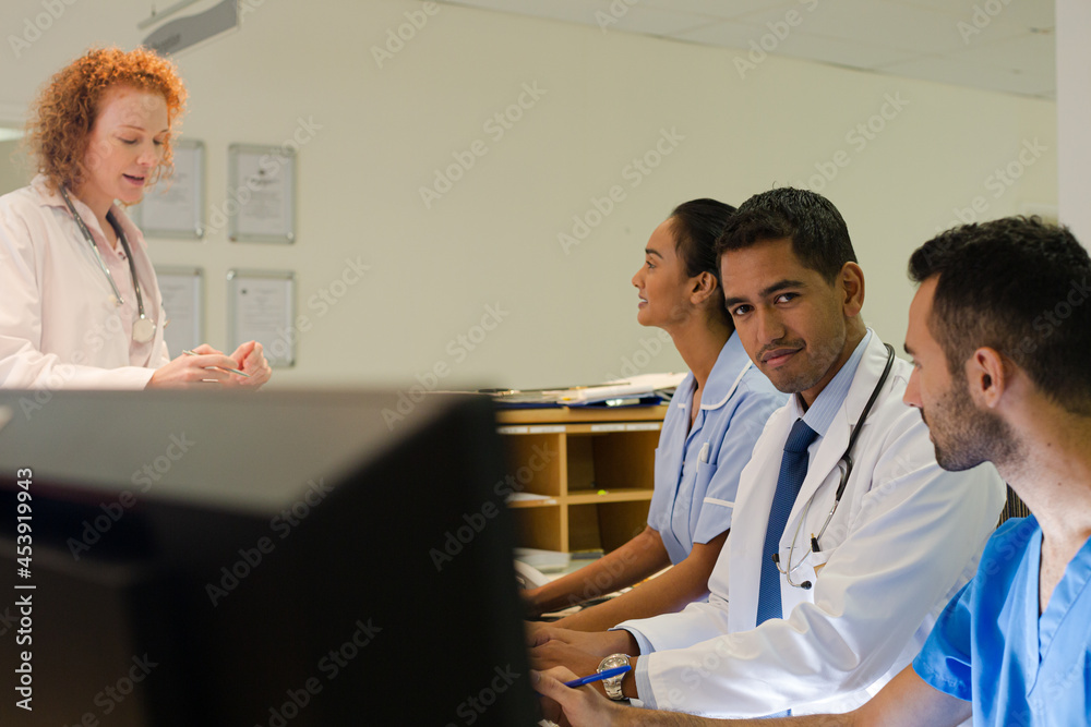 Hospital staff talking at front desk