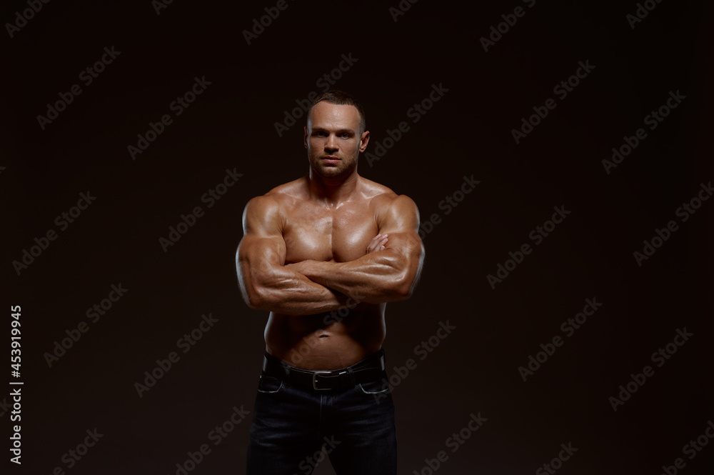 Fototapeta premium Male muscular athlete shows his power in studio