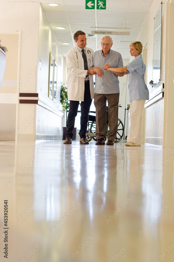 Doctor and nurse talking to patient in hospital room