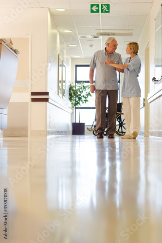 Older patient and nurse standing in hospital