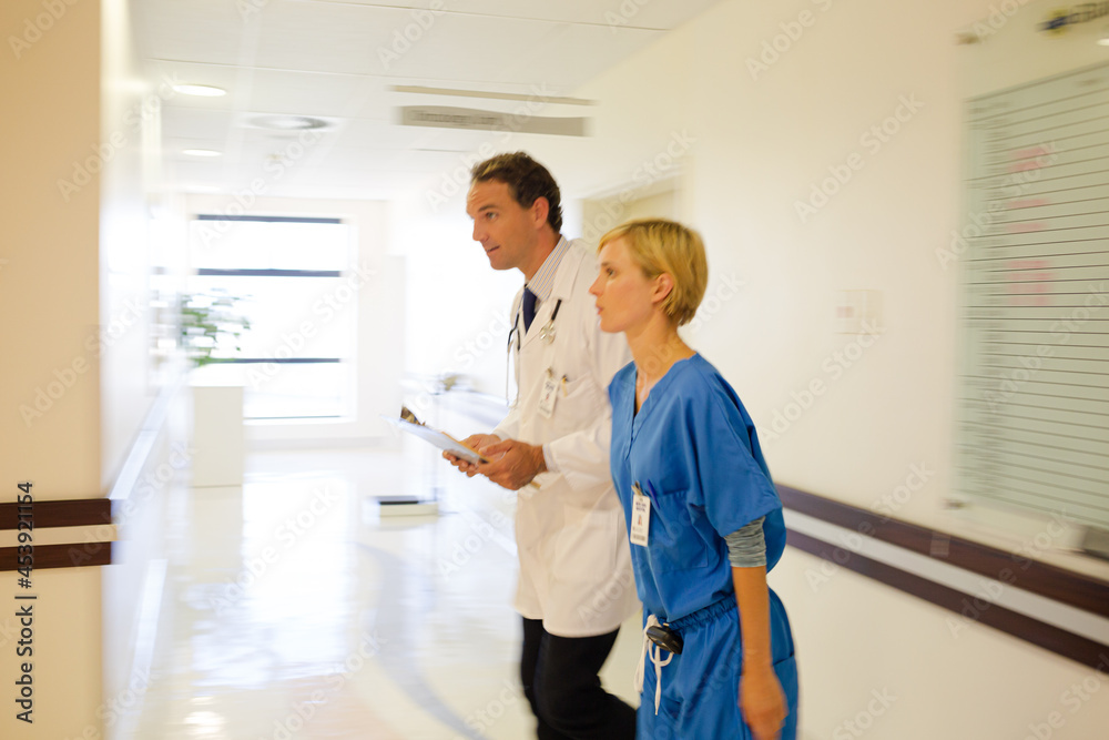 Fototapeta premium Nurse and doctor walking in hospital hallway
