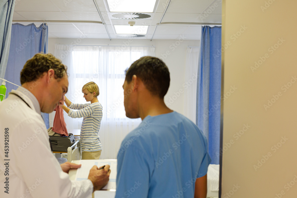 Doctors standing in hospital room Doctors standing in hospital room