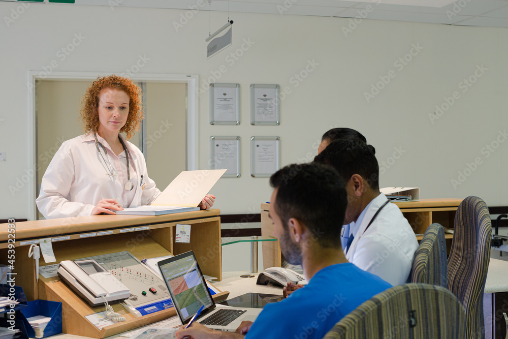 Hospital staff talking at front desk