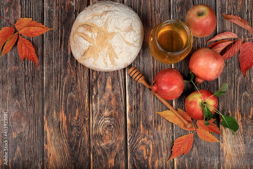 Harvesting concept, Jewish New Year Rosh Hashanah background.Autumn composition with apples, honey, pomegranate and bread on an old wooden table, ecological food. Healthy eating, body detoxification