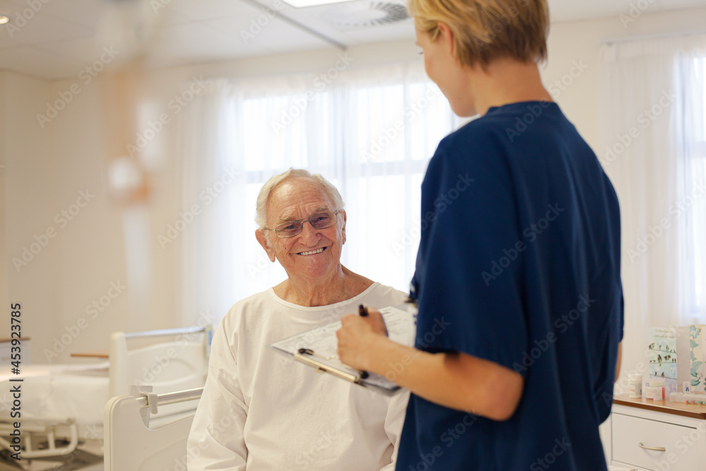 Nurse and older patient talking in hospital room Nurse and older patient talking in hospital room
