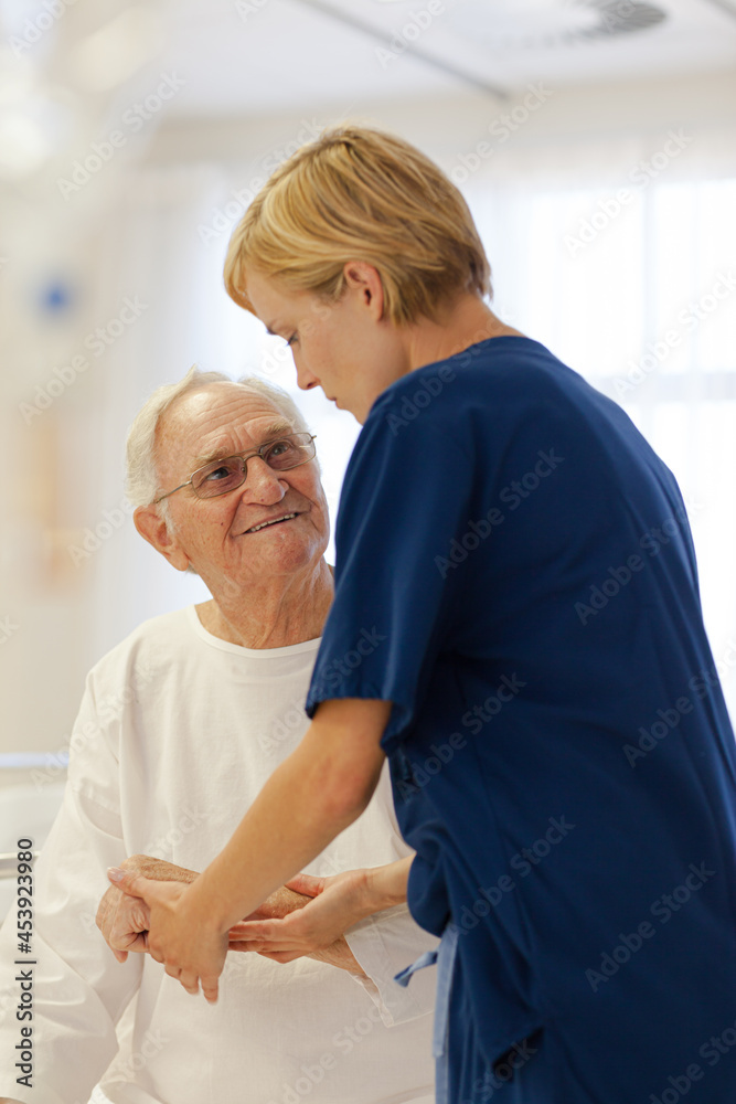 Nurse reading older patient's medical bracelet in hospital Nurse reading older patient's medical bracelet in hospital