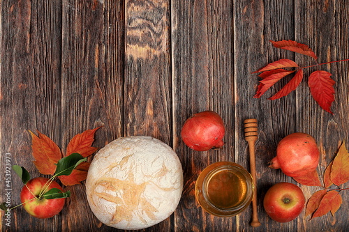 Harvesting concept, Jewish New Year Rosh Hashanah background.Autumn composition with apples, honey, pomegranate and bread on an old wooden table, ecological food. Healthy eating,