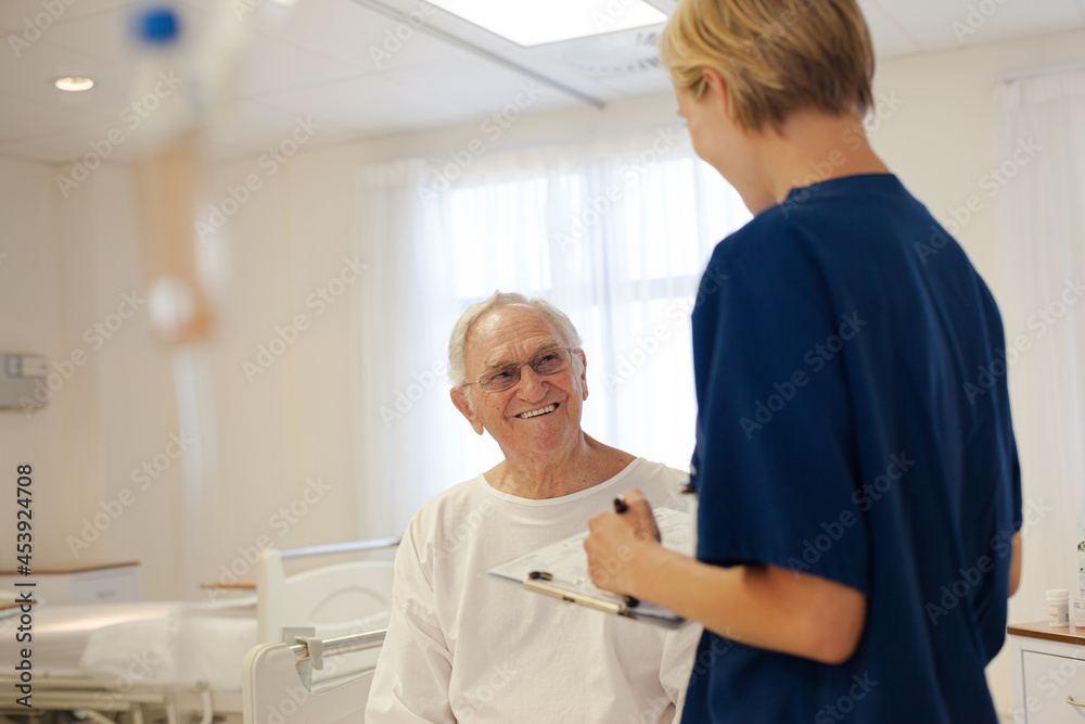 Obraz premium Nurse and older patient talking in hospital room