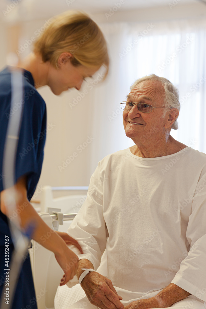 Fototapeta premium Nurse reading older patient's medical bracelet in hospital