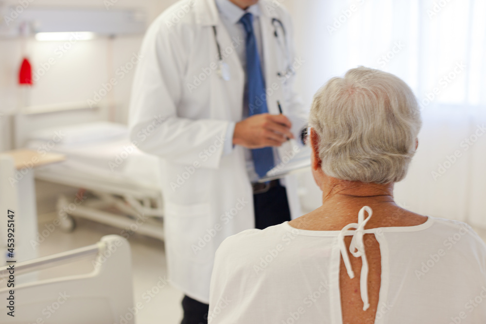 Doctor talking with patient in hospital room Doctor talking with patient in hospital room