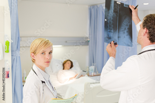 Doctors examining x-rays in hospital room