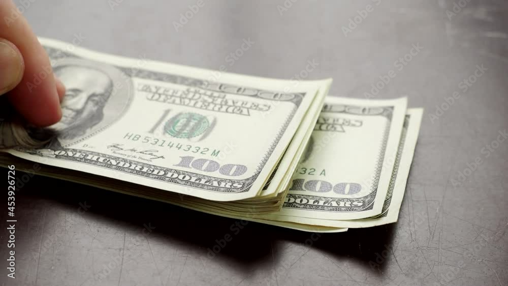 Hand counting pile of one hundred US banknotes over wooden table in 4K VIDEO. Cash of hundred dollar bills, paper money currency. Hand counting pile of one hundred US banknotes over wooden table in 4K VIDEO. Cash of hundred dollar bills, paper money currency.