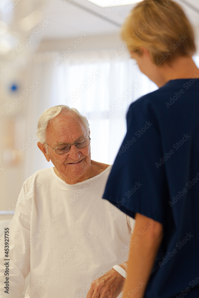 Nurse reading older patient's medical bracelet in hospital Nurse reading older patient's medical bracelet in hospital