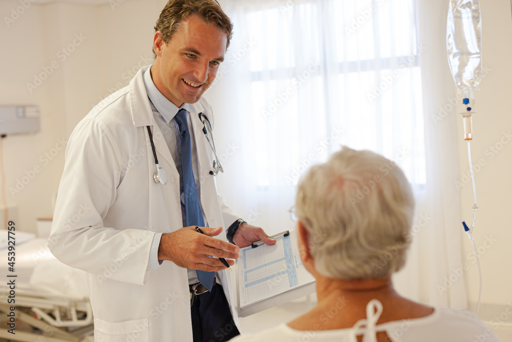 Doctor talking with patient in hospital room Doctor talking with patient in hospital room