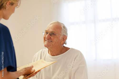 Nurse talking with older patient in hospital