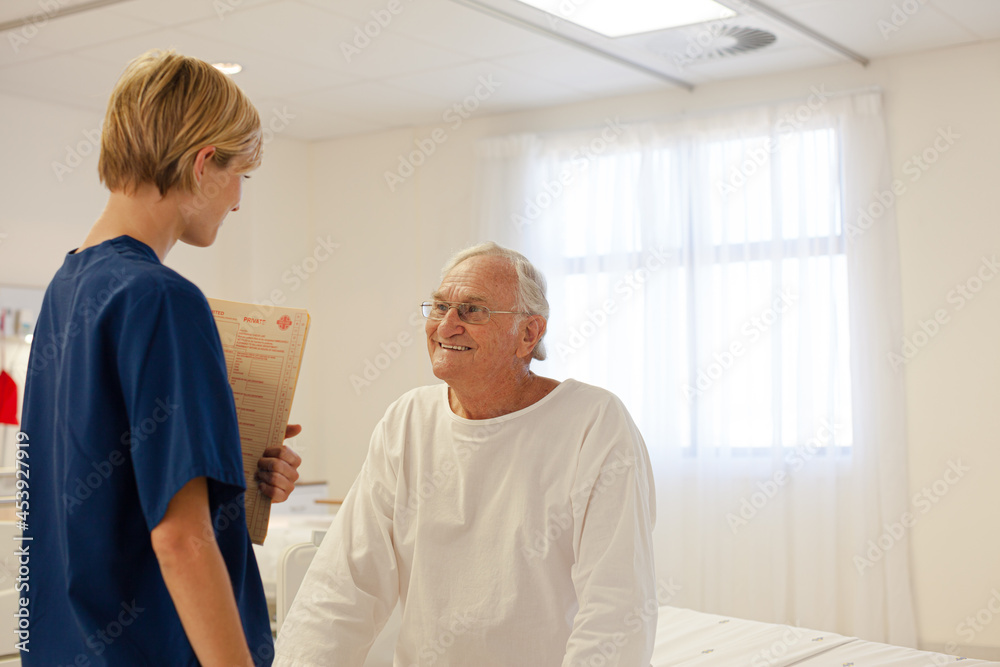 Fototapeta premium Nurse talking with older patient in hospital