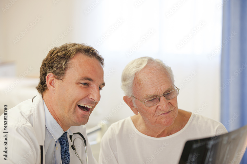 Doctor showing x-rays to older patient in hospital room Doctor showing x-rays to older patient in hospital room