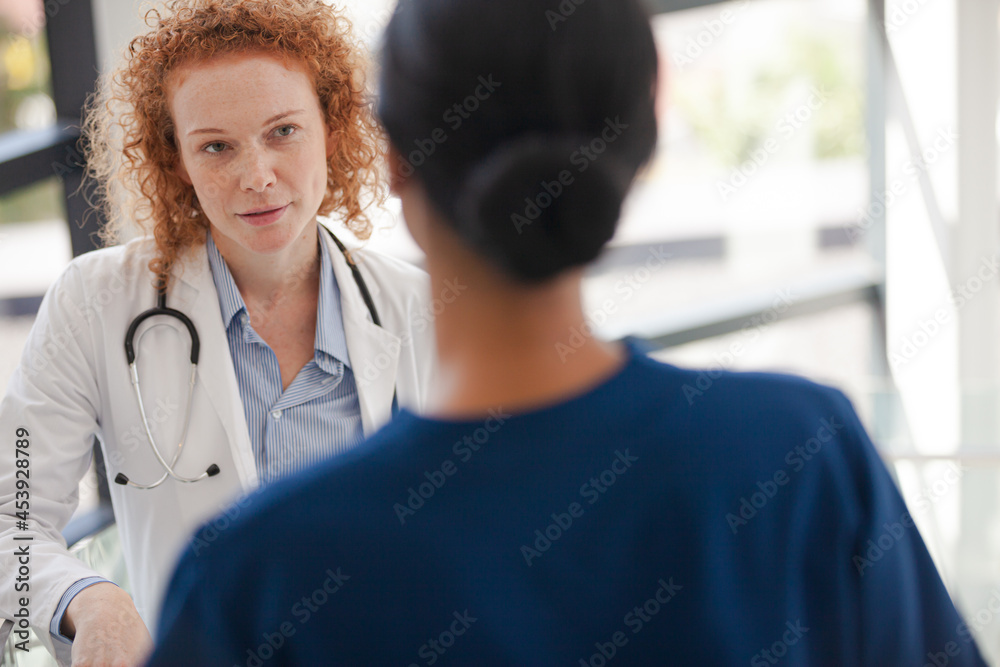 Doctor and nurse talking in hospital hallway Doctor and nurse talking in hospital hallway