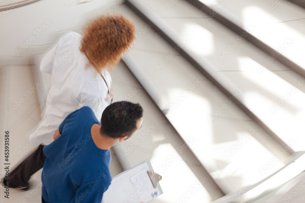 Doctor and nurse walking on hospital steps Doctor and nurse walking on hospital steps