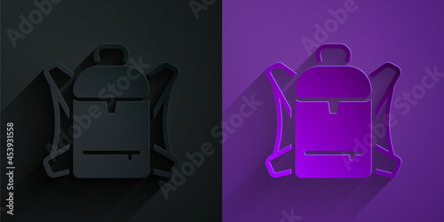 Paper cut Hiking backpack icon isolated on black on purple background. Camping and mountain exploring backpack. Paper art style. Vector