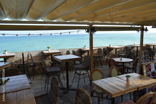 Restaurante costero con sillas y mesas