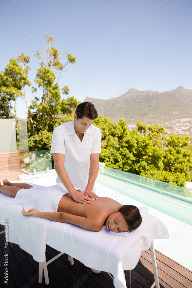 Woman receiving massage poolside at spa Woman receiving massage poolside at spa